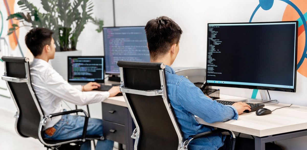 Engineers working across multiple monitors